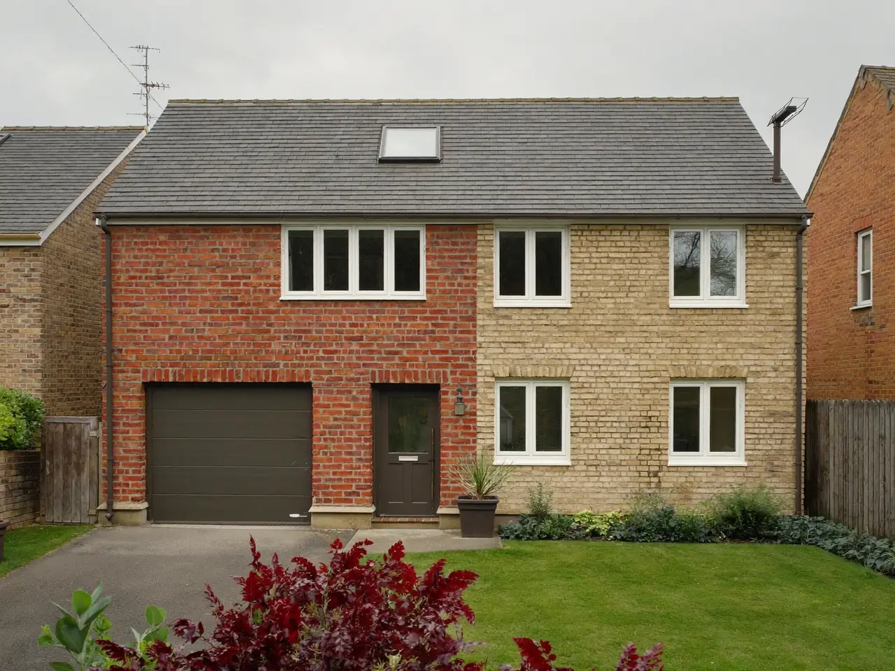 White uPVC windows on a red-brick semi-detached house